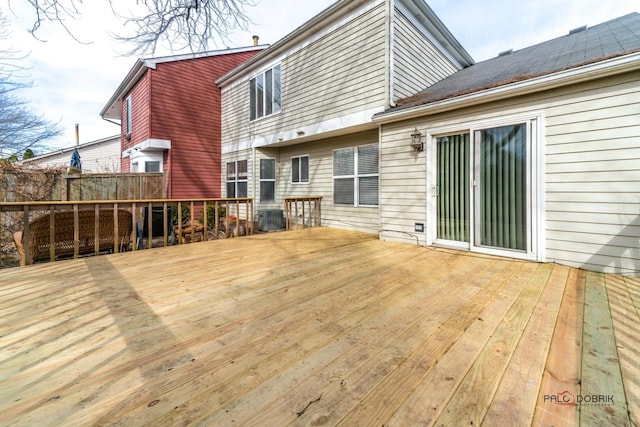 wooden terrace featuring central AC unit and fence