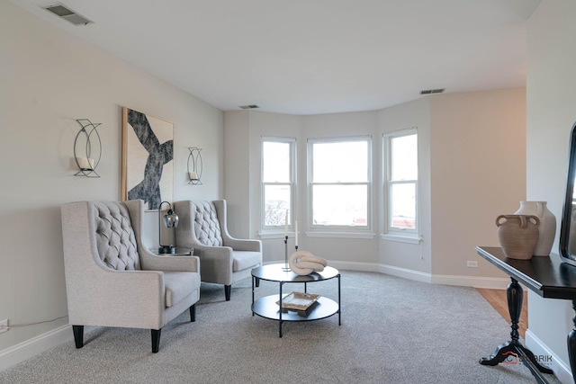 sitting room featuring carpet flooring, visible vents, and baseboards