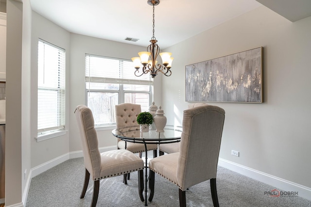 carpeted dining room with baseboards, visible vents, and an inviting chandelier