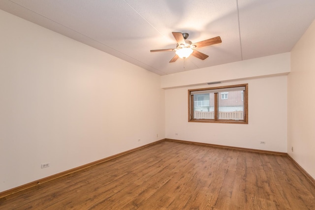 empty room with ceiling fan, baseboards, and wood finished floors