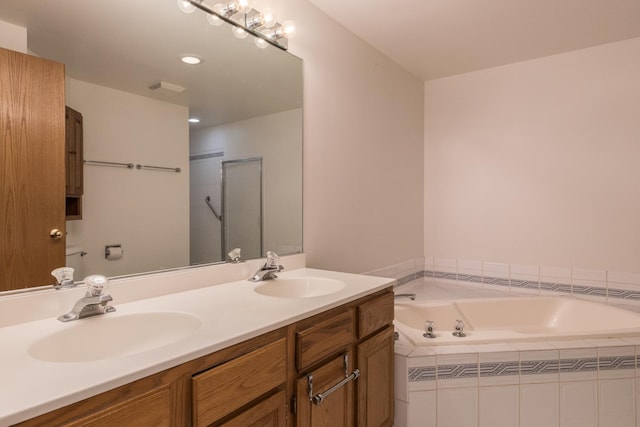 bathroom featuring a garden tub, a sink, visible vents, and double vanity