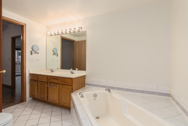 bathroom with double vanity, toilet, a garden tub, tile patterned flooring, and a sink