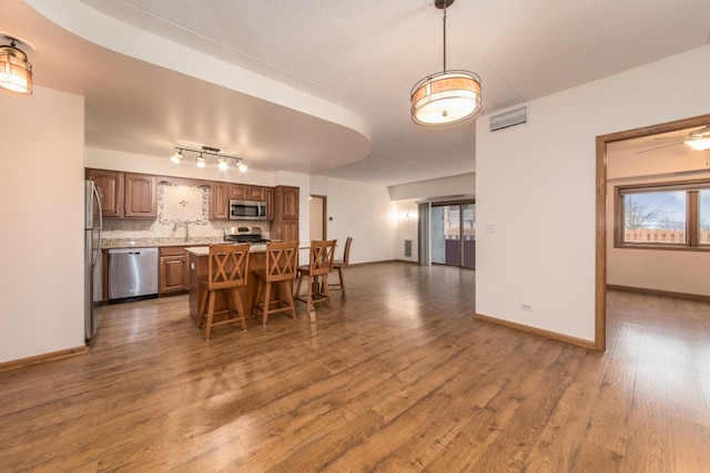 dining area with baseboards, visible vents, and dark wood finished floors