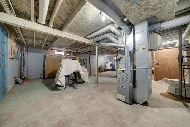 basement featuring electric panel and heating unit