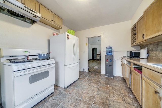 kitchen featuring light brown cabinets, under cabinet range hood, white appliances, visible vents, and stone finish flooring