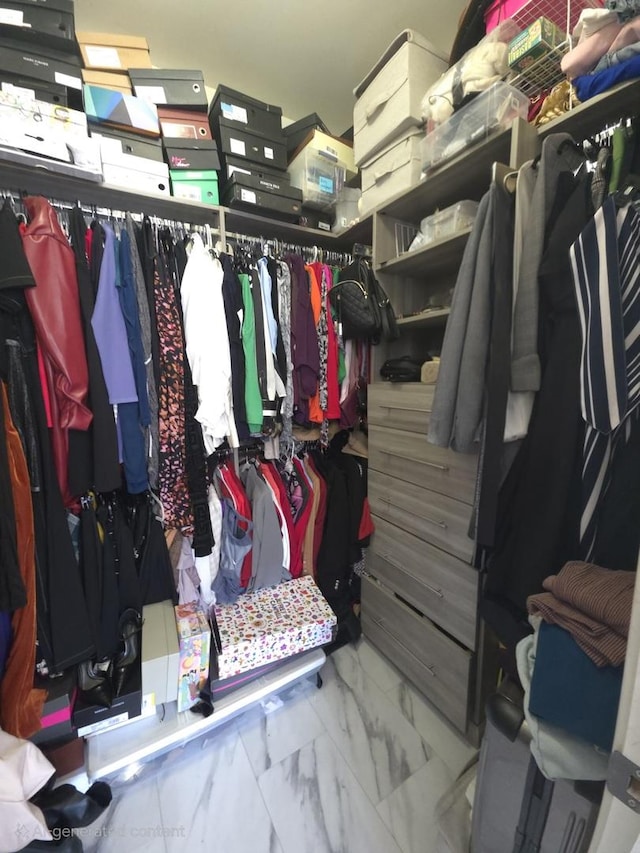 walk in closet with marble finish floor