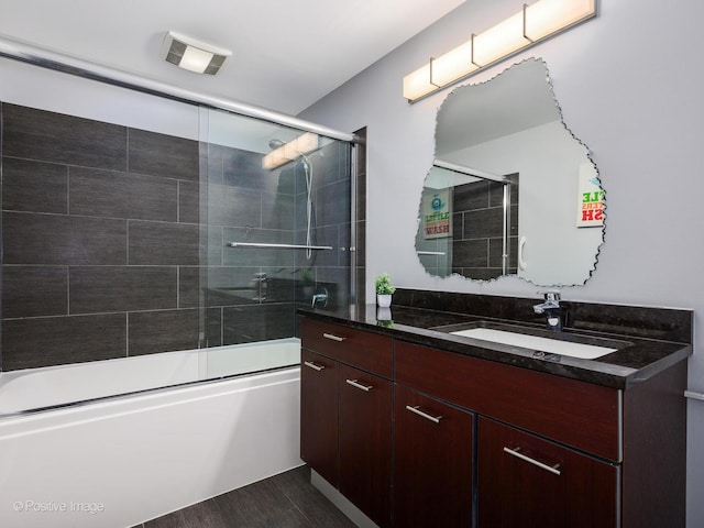 full bath with visible vents, combined bath / shower with glass door, wood finished floors, and vanity
