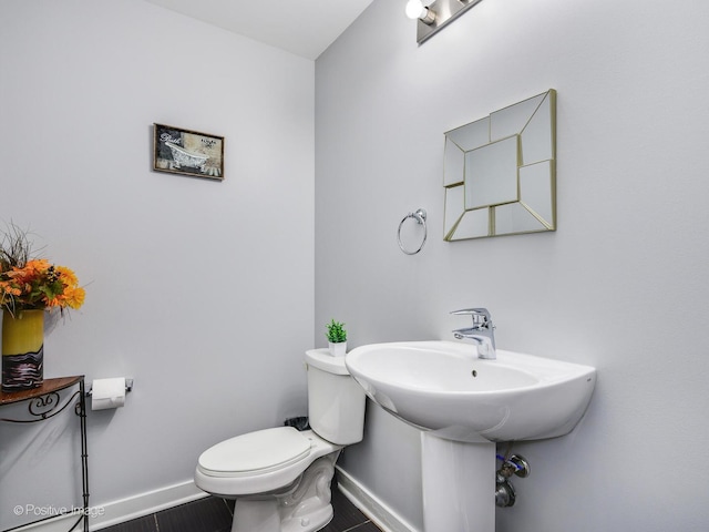 bathroom with baseboards and toilet