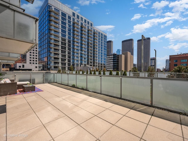view of patio / terrace with a view of city and fence