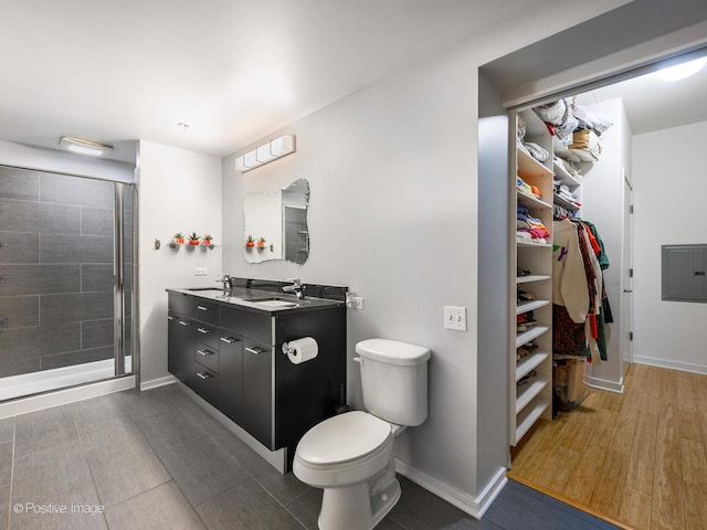bathroom with baseboards, vanity, electric panel, and a stall shower