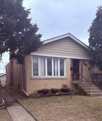 view of front of home with brick siding and a front lawn