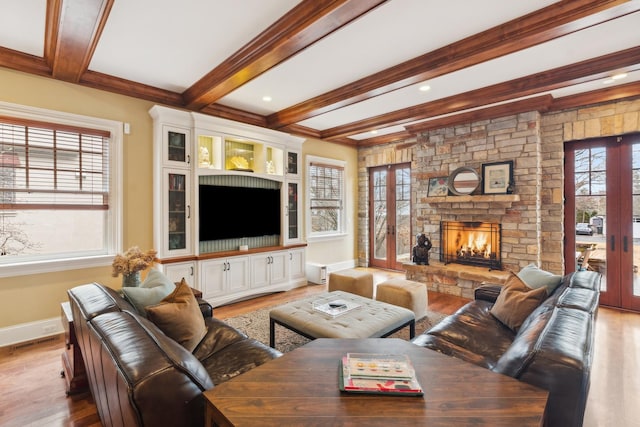 living area with light wood-style flooring, a fireplace, baseboards, french doors, and beamed ceiling