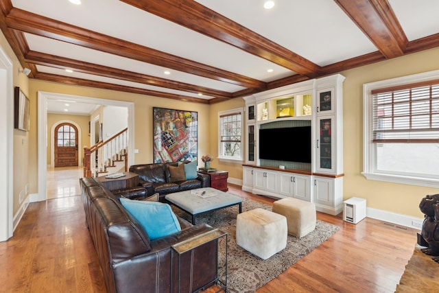 living room featuring plenty of natural light, beam ceiling, and wood finished floors