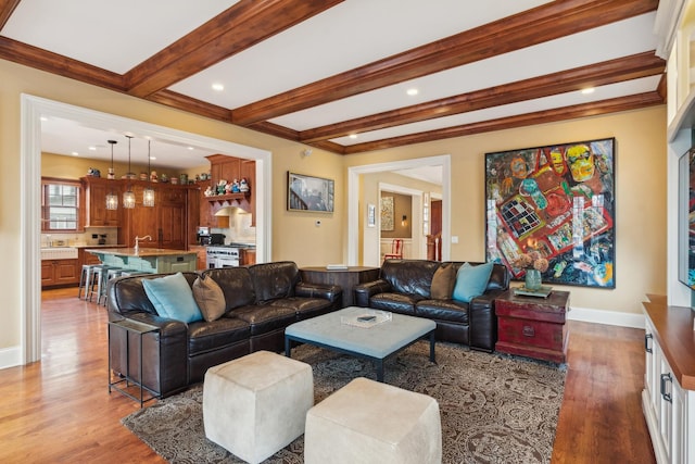 living room with beam ceiling, crown molding, recessed lighting, wood finished floors, and baseboards