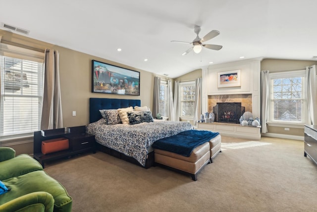 bedroom featuring lofted ceiling, recessed lighting, light colored carpet, visible vents, and a lit fireplace