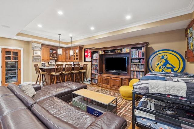 living area with ornamental molding, a tray ceiling, indoor bar, and recessed lighting