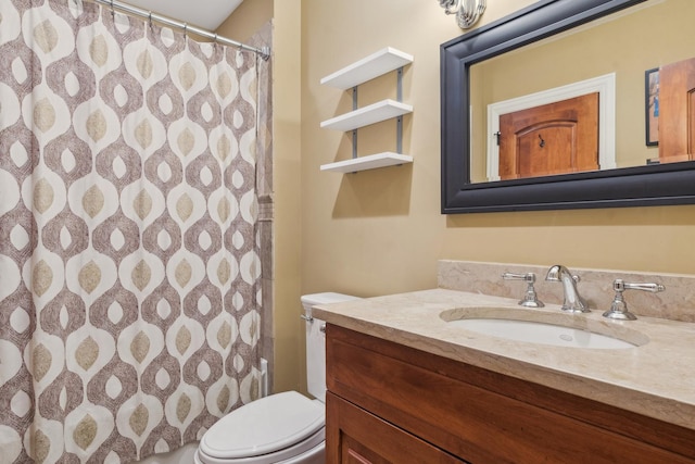 bathroom featuring curtained shower, vanity, and toilet