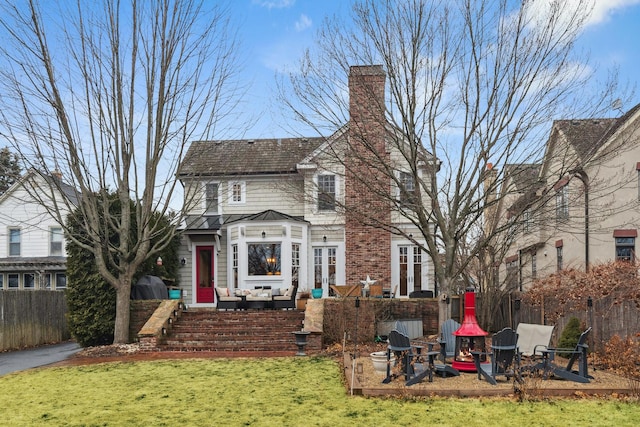 back of property featuring a yard, a chimney, and fence