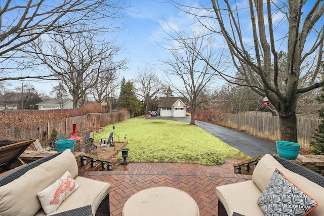 view of yard featuring fence private yard, a patio, and an outbuilding