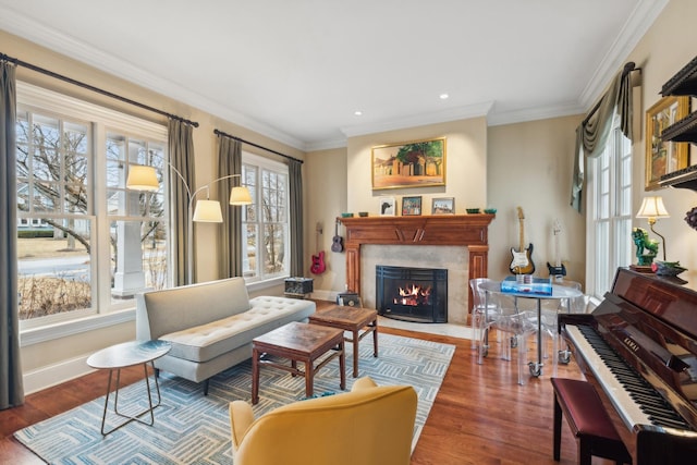 sitting room featuring baseboards, crown molding, a premium fireplace, and wood finished floors