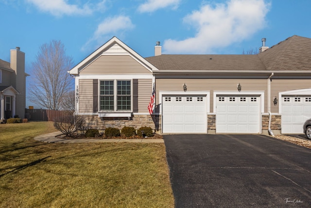 view of front facade featuring stone siding, driveway, an attached garage, and a front yard