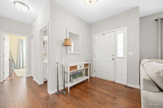 entrance foyer featuring visible vents, plenty of natural light, dark wood-style floors, and baseboards