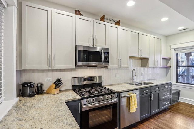 kitchen featuring dark wood-style floors, visible vents, decorative backsplash, appliances with stainless steel finishes, and a sink