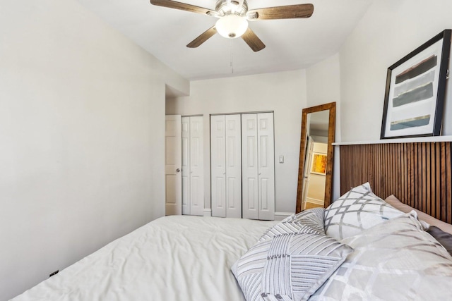 bedroom with a ceiling fan and multiple closets