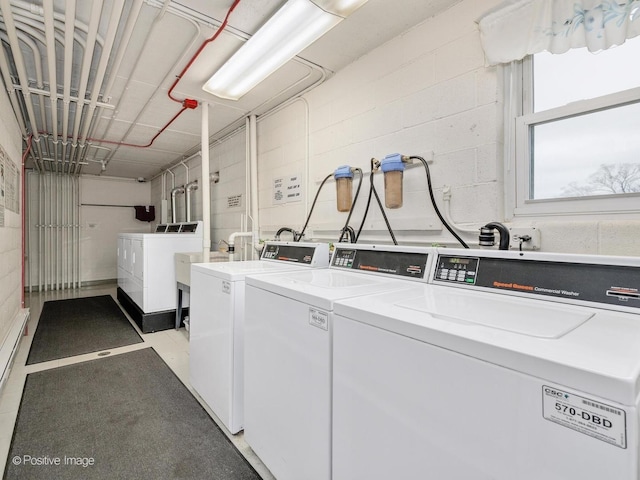 shared laundry area with washing machine and dryer and concrete block wall