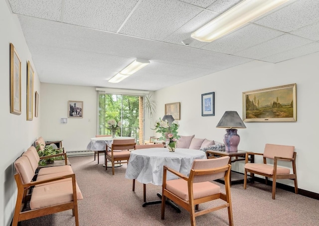 dining area with light carpet, a baseboard heating unit, and a paneled ceiling