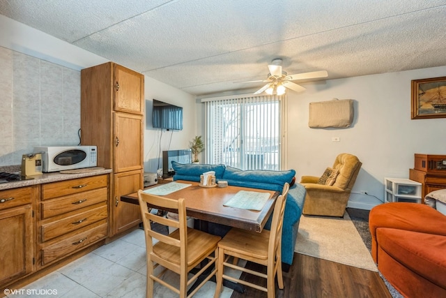 dining room with ceiling fan and a textured ceiling