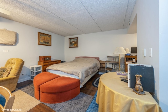 bedroom with vaulted ceiling, a textured ceiling, and wood finished floors