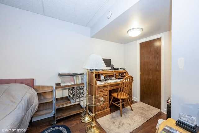 office area with a textured ceiling, baseboards, and wood finished floors