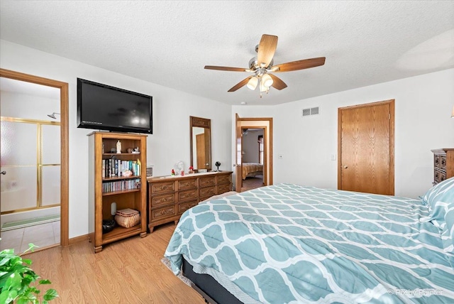 bedroom featuring a ceiling fan, light wood-type flooring, visible vents, and a textured ceiling