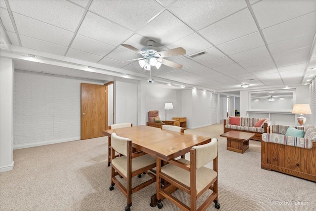 carpeted dining area featuring a paneled ceiling, visible vents, and a ceiling fan