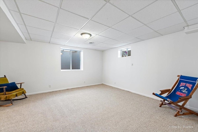 unfurnished room with a paneled ceiling, carpet, and baseboards