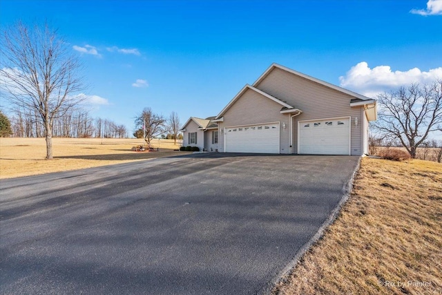 ranch-style house with an attached garage and aphalt driveway