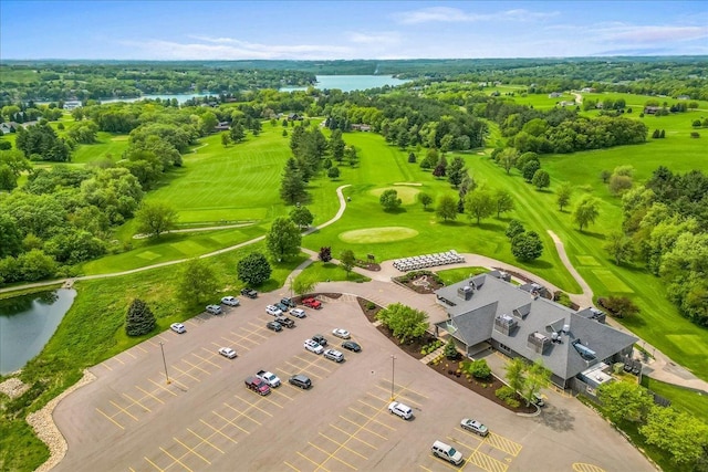 drone / aerial view with a water view and view of golf course