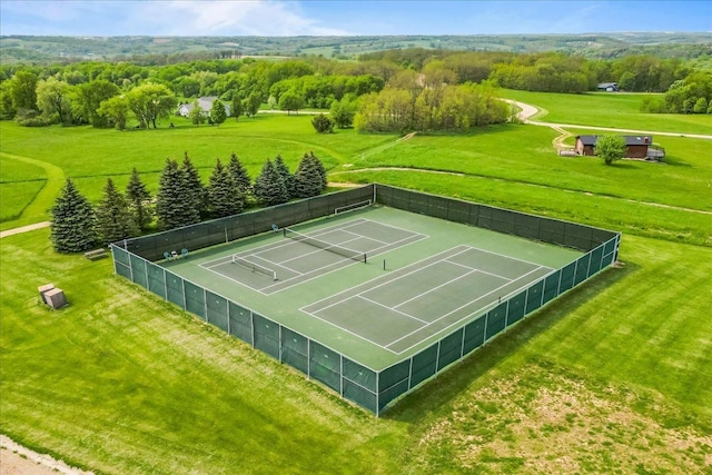 view of sport court featuring a yard, a rural view, and fence