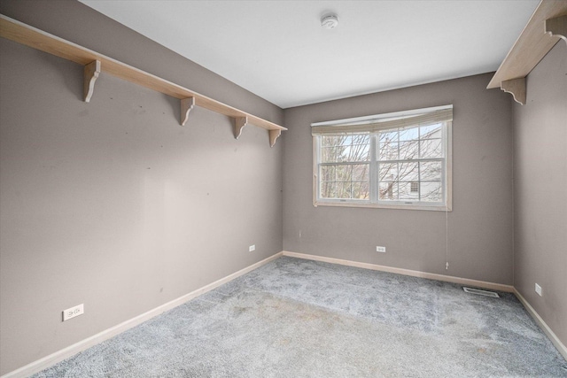 empty room featuring carpet, visible vents, and baseboards