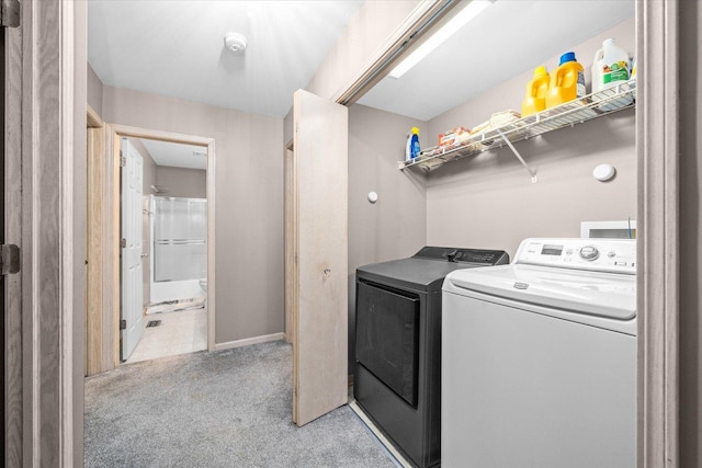 washroom featuring washing machine and dryer, laundry area, and light carpet