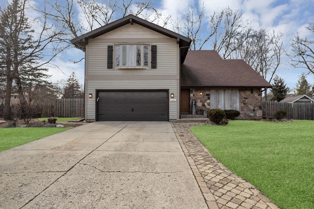 traditional home featuring roof with shingles, a front yard, fence, a garage, and driveway