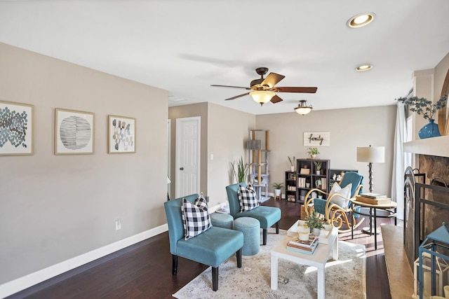 living area featuring a fireplace, recessed lighting, a ceiling fan, wood finished floors, and baseboards