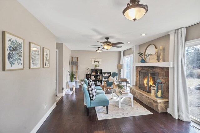 living area featuring a fireplace, baseboards, wood finished floors, and recessed lighting