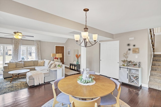 dining area with ceiling fan with notable chandelier, dark wood-type flooring, stairway, and baseboards