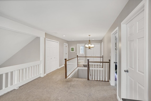 corridor with a chandelier, recessed lighting, carpet flooring, an upstairs landing, and baseboards