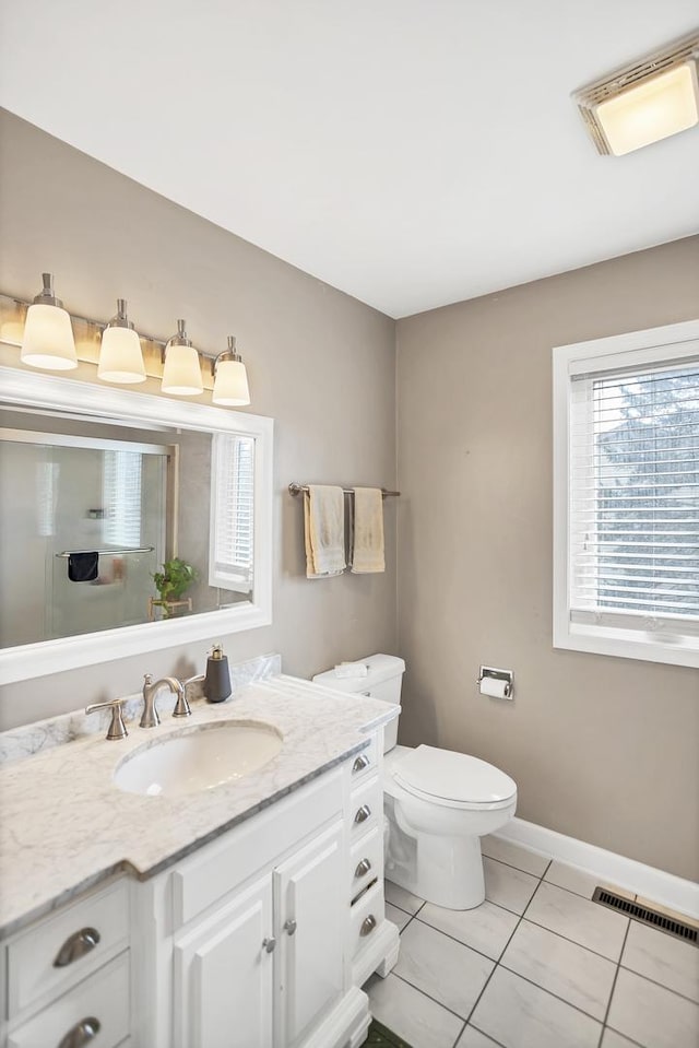 bathroom with baseboards, visible vents, toilet, tile patterned floors, and vanity