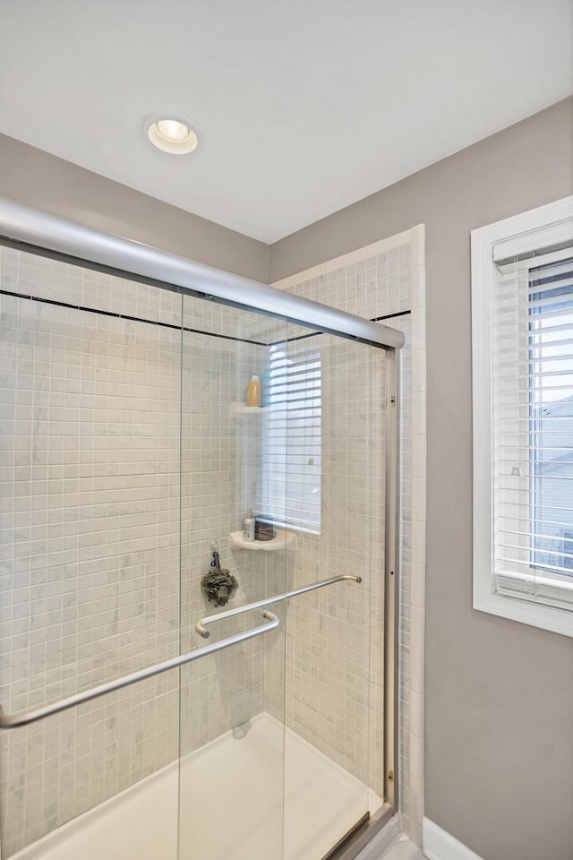 bathroom with a stall shower and baseboards