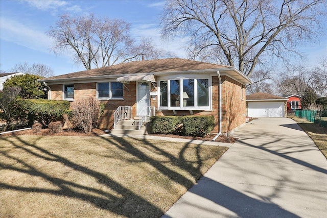 view of front of house featuring an outbuilding, brick siding, a front lawn, and a garage