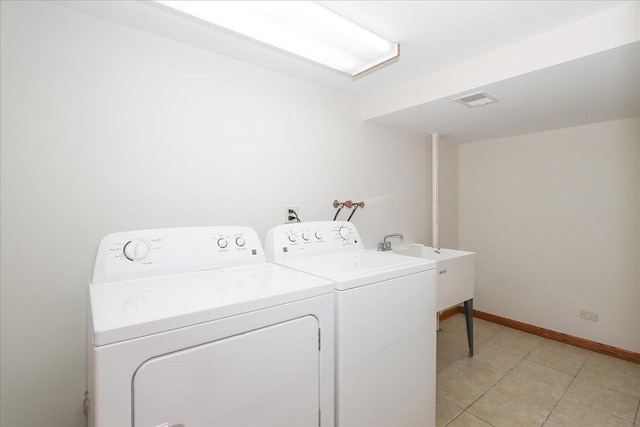 laundry area with visible vents, washing machine and dryer, light tile patterned flooring, laundry area, and baseboards